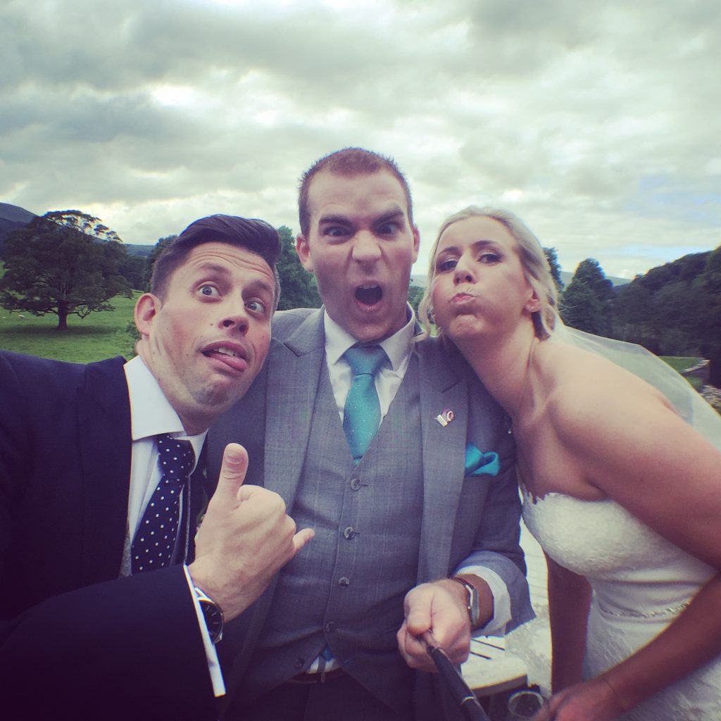 bride and groom with inn at whitewell magician sam fitton pulling a silly face